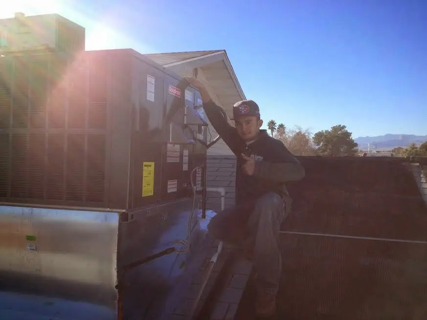 HVAC technician performing Boiler Repair on a rooftop unit in Montgomery